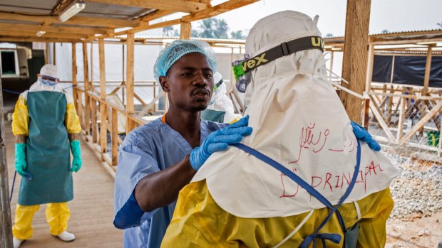 A health care worker prepares a colleague's protective gear at an Ebola virus clinic operated by the International Medical Corps in Makeni, Sierra Leone. The World Health Organisation says  its tally of Ebola deaths has passed 10,000, mostly in West Africa.  