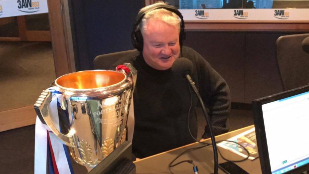 United: Bulldogs' chairman Peter Gordon on radio with the premiership cup.