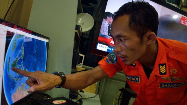 Last contact: An official from Indonesia's national search and rescue agency in Medan, North Sumatra, points to the position where AirAsia flight QZ 8501 went missing off the waters of Indonesia.