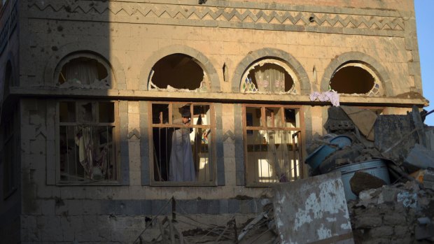 A boy looks from the window of his damaged house at the site of a Saudi-led airstrike near Yemen's Defence Ministry complex in Sanaa last Saturday.