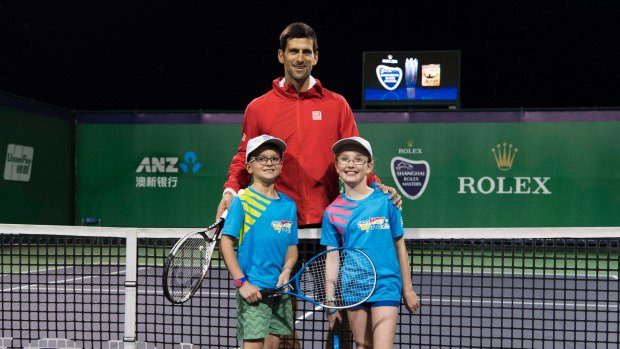 Novak Djokovic with Canberra's Caillie Warwick and Aston Monteleone after winning a Hot Shots competition.