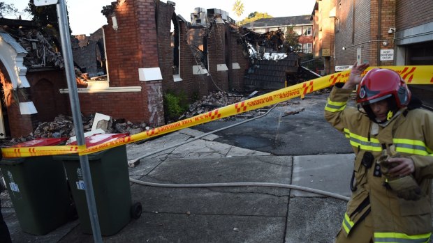 A firefighter inspects the ruins of the Macedonian Orthodox Church of the Resurrection in Frederick Street, Rockdale.