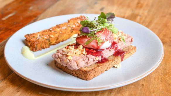 Smorrebrod topped with pork liver pâté, lingonberry jam and a poached egg, with a potato roesti on the side.