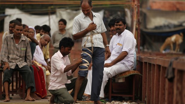 Patients are bound before being cut at a blood-letting clinic in New Delhi, India.