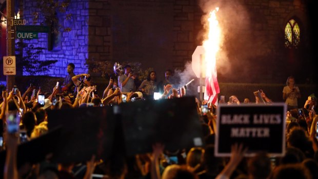 A flag is set on fire as protesters gather in St. Louis, after a judge found a white former St. Louis police officer, Jason Stockley, not guilty of murder.