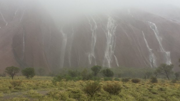 Uluru turns into a cascade of waterfalls as the heavens open up.