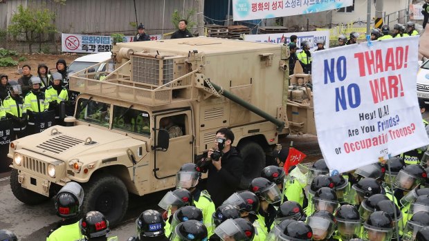A US military vehicle in South Korea moves past protesters opposed to the THAAD missile defence system.