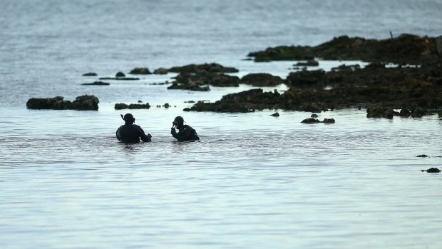 Police divers search for remains near where what is believed to be a skull was discovered on Tuesday.