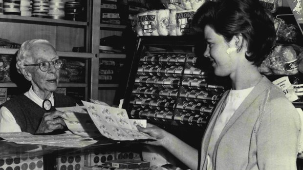 Mary Curtis helps 17-year-old Ann Wise, of the city, choose Swiss cotton motifs in the haberdashery store she has owned for 34 years, in 1963. 