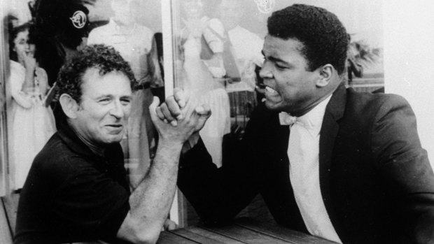 Novelist Norman Mailer is shown arm wrestling with heavyweight champion Muhammad Ali on the terrace of their San Juan hotel, in  1965.