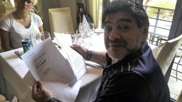 Diego Maradona holds the letter purported to be from Fidel Castro. 