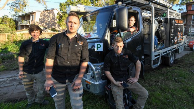 James Thornton (second from left) and his apprentices, who use a mobile phone app to help them navigate across Sydney.