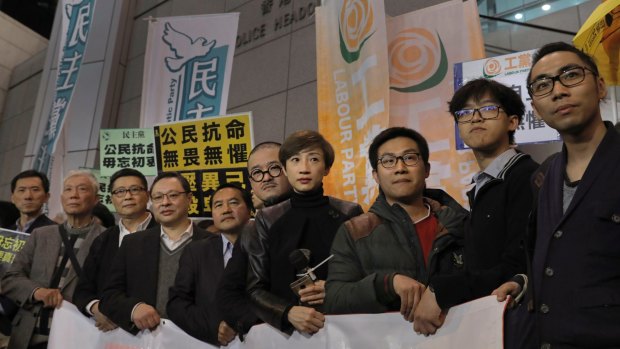 From right, former student leaders Eason Chung, Tommy Cheung, activist Raphael Wong, lawmakers, Tanya Chan, Shiu Ka-chun, former legislator Lee Wing-tat, founders of the Occupy Central civil disobedience movement, Benny Tai, Chan Kin-man and Chu Yiu-ming pose for a picture before walking toward a police station in Hong Kong on Monday.