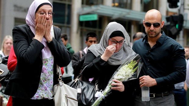 Members of the Muslim community lay flowers at Martin place after 2 people and gunman died when the Siege ended at 2am this morning 