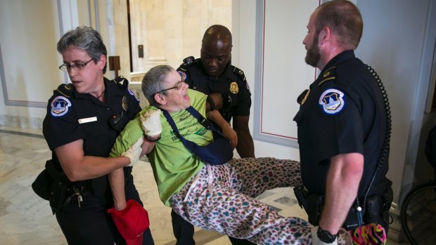 A demonstrator protesting against Medicaid cuts is removed from outside the offices of Senator McConnell on June 22.