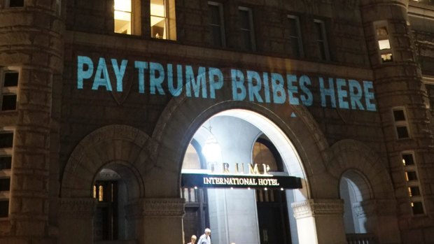 US President Donald Trump's Washington hotel is illuminated with projected messages by Robin Bell, an artist and filmmaker. 