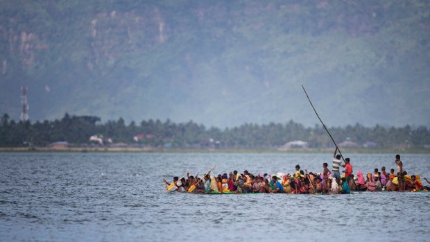 Rohingya Muslims aboard a makeshift raft cross the Naf River from Myanmar into Bangladesh on November 12.