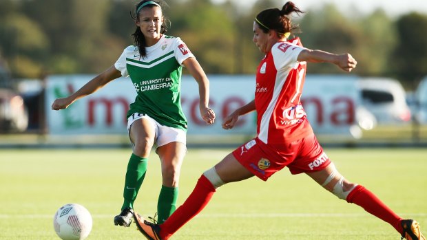 Canberra United defender Rebecca Kiting passes the ball past Rosie Sutton of Adelaide.