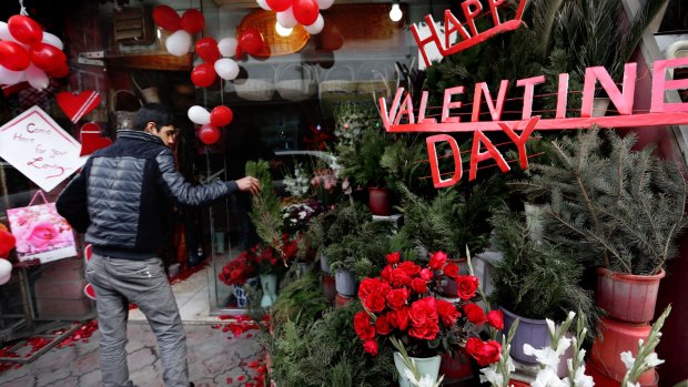 Love amid the carnage: an Afghan flower vendor arranges roses for Valentine's Day in Kabul.
