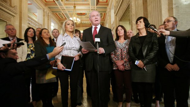 Sinn Fein's Martin McGuinness, centre, stands with members of his party during a press conference at Stormont in Belfast, Northern Ireland, as he gives his reaction to the British government-ordered review.
