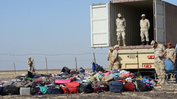 Egyptian soldiers collect personal items belonging to the victims of the Russian  plane that crashed on Egypt's Sinai Peninsula.