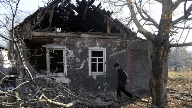War damage: A resident walks in front of his house after the recent shelling in Donetsk.