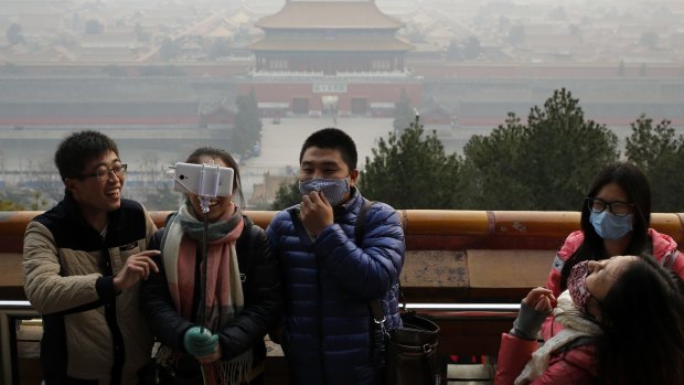 Visitors, some wearing masks to protect themselves from pollution, in Jingshan Park on a polluted day in Beijing, last December. 