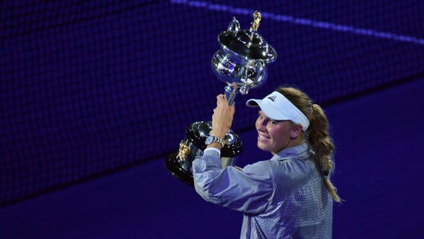 Caroline Wozniacki lifts the trophy, after winning her first grand slam event.