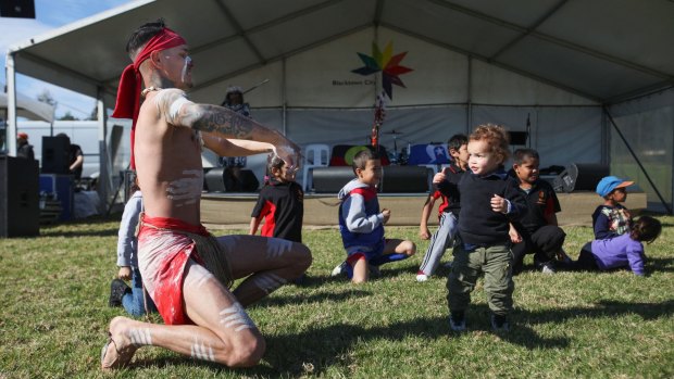 SYDNEY, AUSTRALIA - JULY 04:  Indigenous Dancer Darren Compton with children at NAIDOC Family Fun Day.