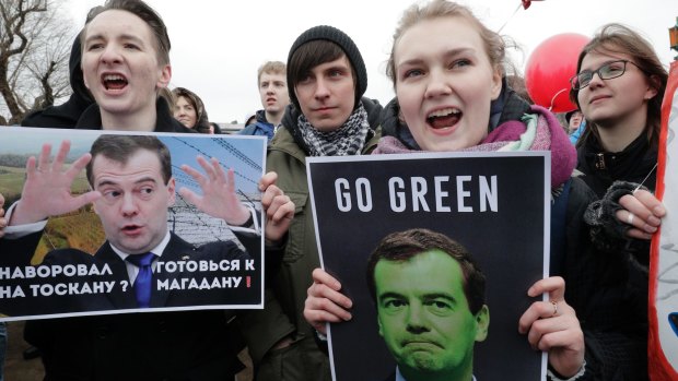 Protesters hold posters depicting Russian Prime Minister Dmitry Medvedev, whom Mr Navalny has accused of corruption.
