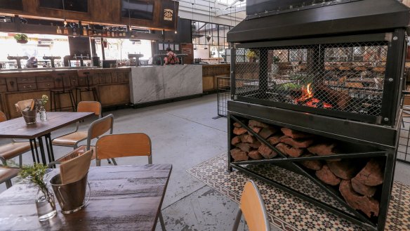 The industrial metal fireplace is the only thing allowed to smoke at Stomping Ground Beer Hall.
