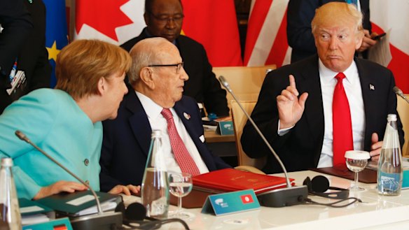 US President Donald Trump talks to German Chancellor Angela Merkel at the G7 summit.