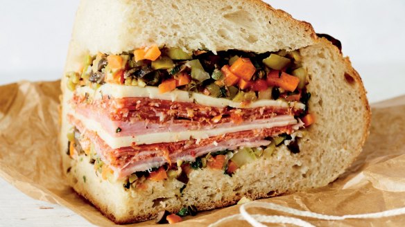 A portion of muffuletta piled with deli meats.