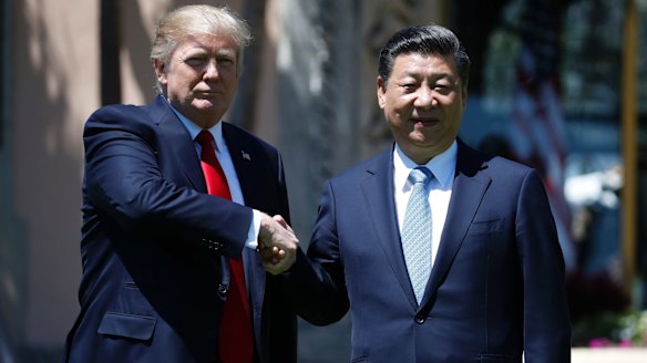 US President Donald Trump and Chinese President Xi Jinping pause for photographs on Friday.