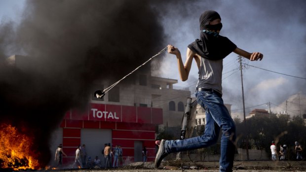 A young Palestinian hurls a stone during clashes with Israeli troops near Ramallah on Wednesday.