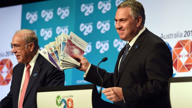 Treasurer Joe Hockey holds up a report with OECD secretary-general Angel Gurria in Cairns.