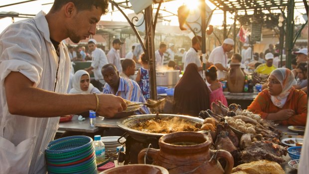 A chef preparing food at a stall in the Djemaa el Fna in the medina of Marrakech, Morocco. Every night the main square fills with dozens of food vendors and their carts