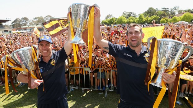 Alastair Clarkson and Luke Hodge show off Hawhtorn's trio of premiership trophies.