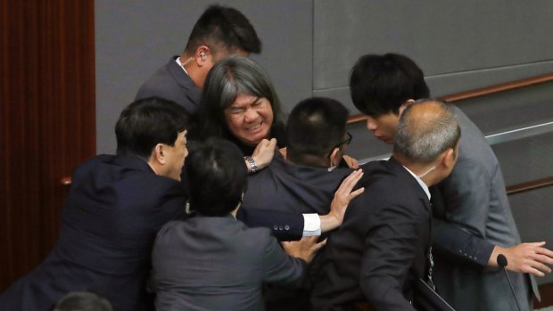 Lawmaker Leung Kwok-hung, known as "Long Hair",  tries to break through the security guards during the election of president of the Legislative Council in Hong Kong.