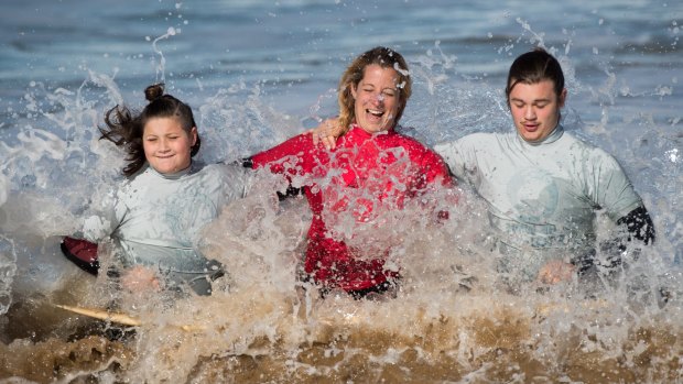Ocean Mind founder Rachael Parker says surfing helped her own depression.
Siblings Isabella and Sebastian with  Rachael [centre].