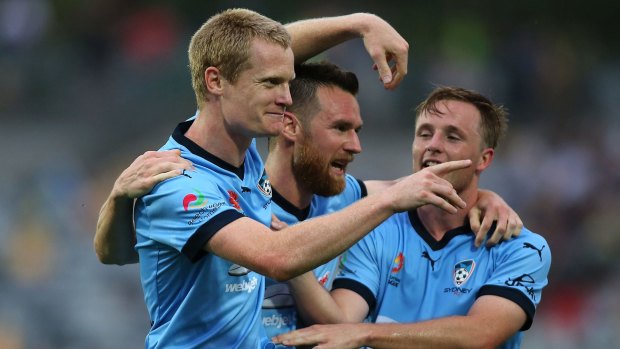 On target: Matt Simon celebrates with teammates after scoring for Sydney FC.