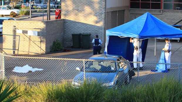 Steve Hodge's body lies outside the Warners Bay Post Office covered by a sheet.
