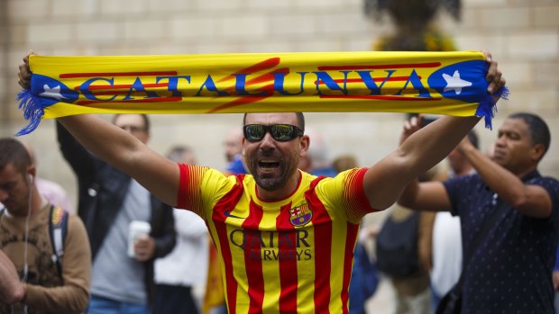 A man shouts while holding up a scarf reading 'Catalunya' during a pro-independence demonstration . 