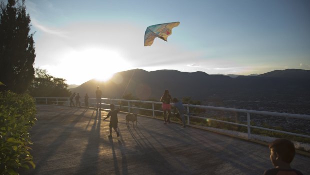 A child flies a kite as others look out over the city of Iguala, Mexico. Iguala was thrust into the limelight in 2014 when three students were killed and 43 others disappeared allegedly at hands of the local police.