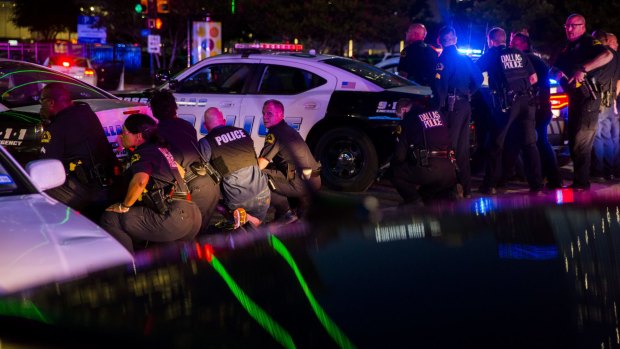 Dallas police officers take cover during the attack.