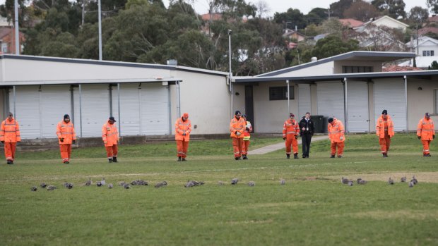 Emergency workers do a line search at Dunstan Reserve in West Brunswick. 