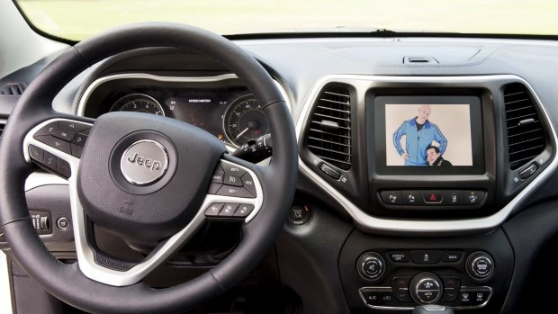 An in-car screen of a Jeep Cherokee shows Chris Miller, left, and Chris Valasek, who are demonstrating their ability to remotely control the vehicle's computer system.