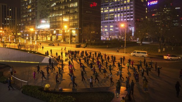 Men and women take part in a mass dance in downtown Beijing on March 24, 2015.