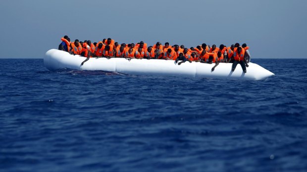Migrants on a rubber dinghy wait to be rescued by a Migrant Offshore Aid Station ship off the coast of Libya in August.