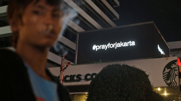 An electronic screen above the Starbucks cafe where the attack took place displays the message "#prayforjakarta". 